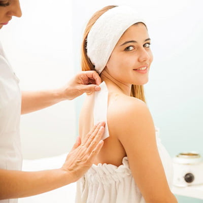 A woman enjoying a facial treatment at a spa, receiving relaxation and rejuvenation for her skin.