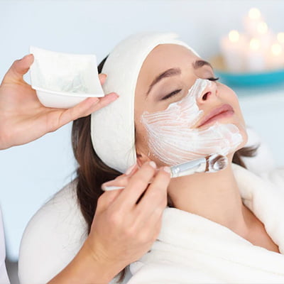 A woman enjoying a facial treatment at a spa, receiving professional care for her skin's rejuvenation and relaxation.